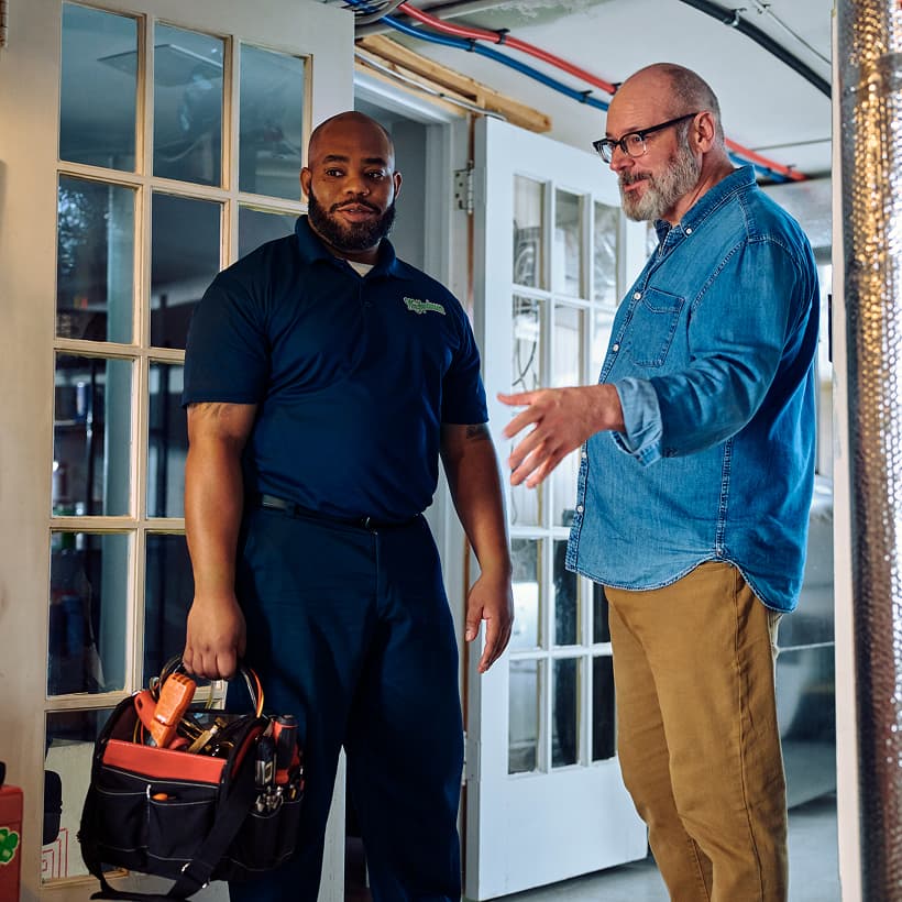 A Wm Henderson technician discusses the repair and installation services with a homeowner.
