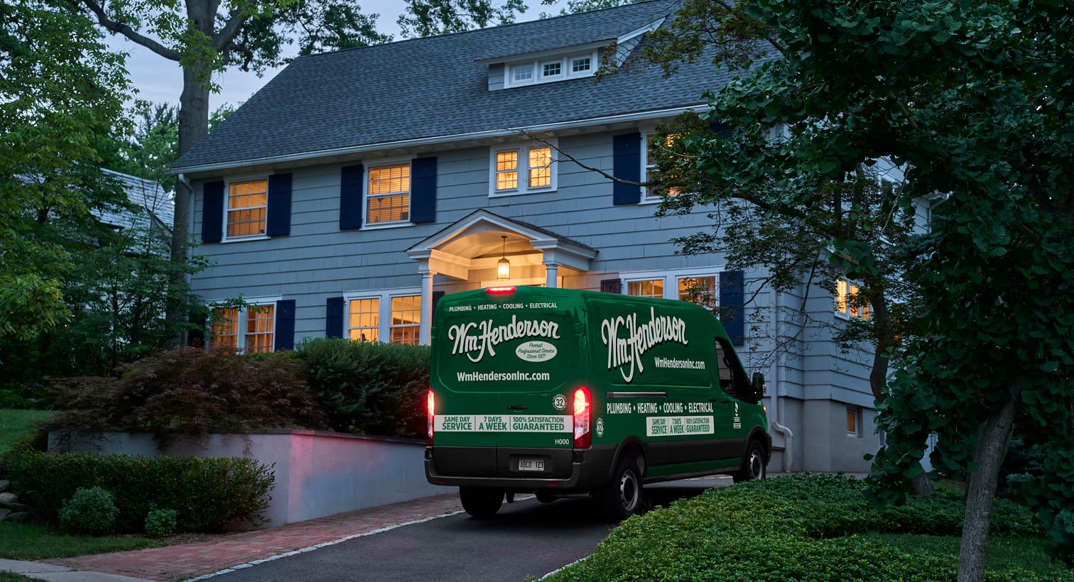 A Wm Henderson service van parked in a residential driveway at night, arriving to provide 24/7 emergency heating repair services.